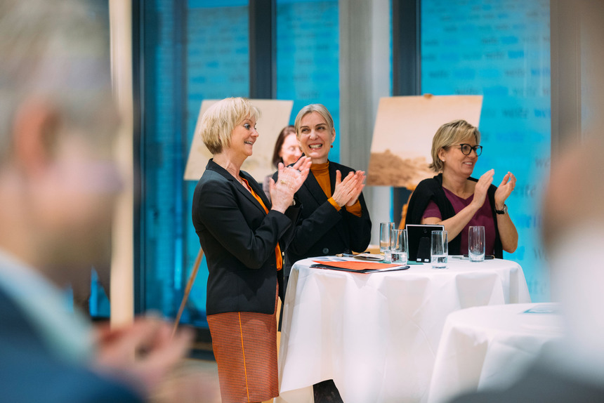 Drei Frauen spenden Beifall.