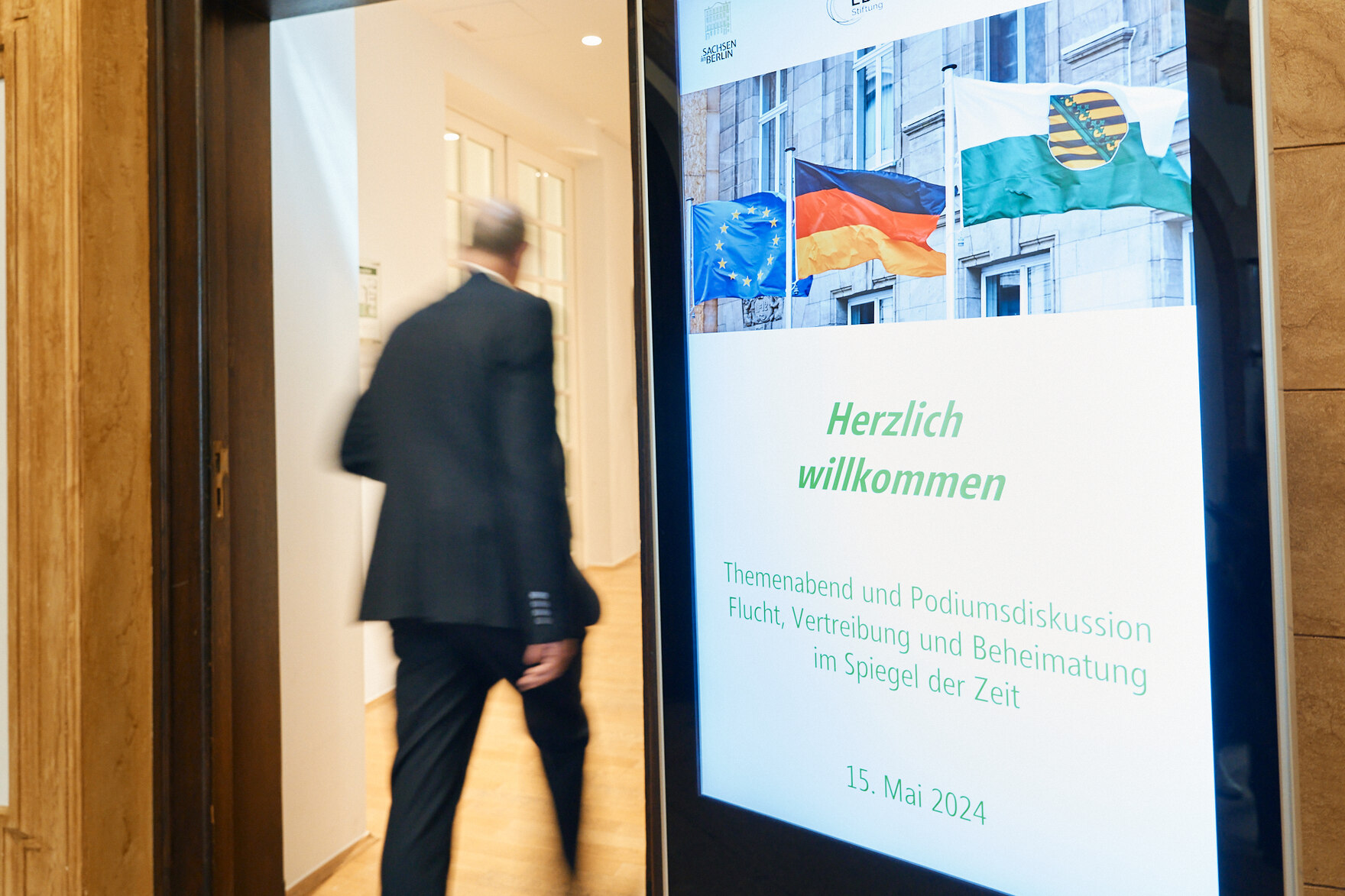 Hinweistafel mit Veranstaltungsankündigung neben der Eingangstür