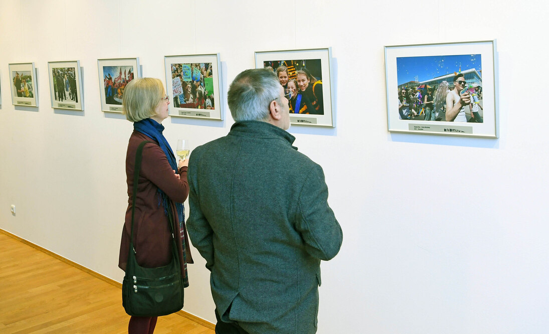 Ein Mann und eine Frau betrachten eine Fotoausstellung.