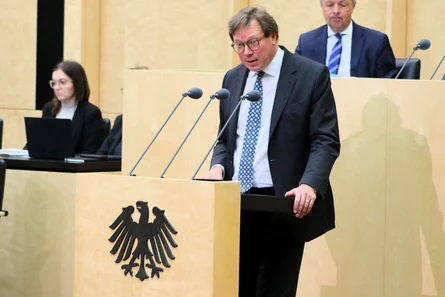 Ein Mann in Anzug und Krawatte spricht am Rednerpult